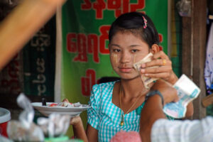 Lokaler Markt am Stadtrand von Yangon. Burma / Myanmar. Junge Burmesin mit Thanaka im Gesicht.